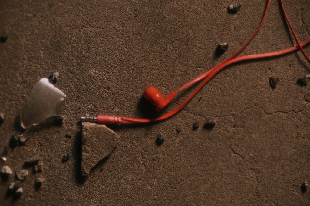 Close-up view of hands testing an RV breakaway cable system, showing the red coiled cable attached to the breakaway switch on