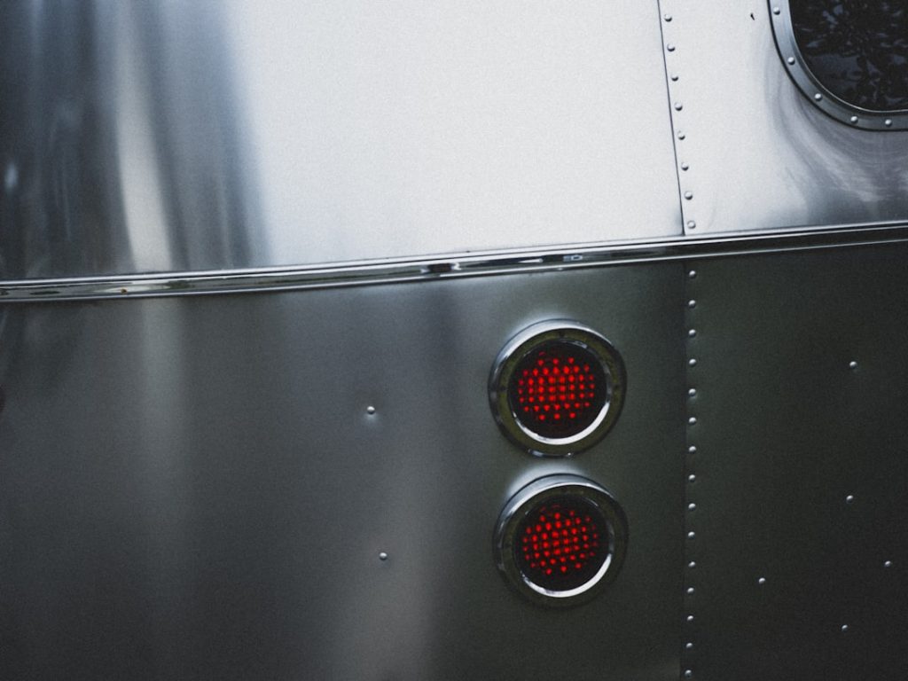 Close-up view of hands removing a glass turntable from an RV microwave, with the plastic coupling ring visible underneath, sh