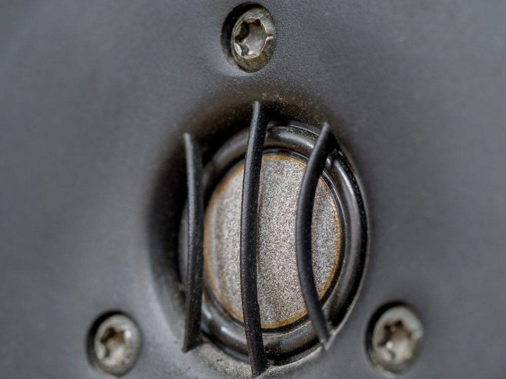 Close-up view of an RV owner's hands installing a grey water diverter valve underneath their travel trailer, with a large col
